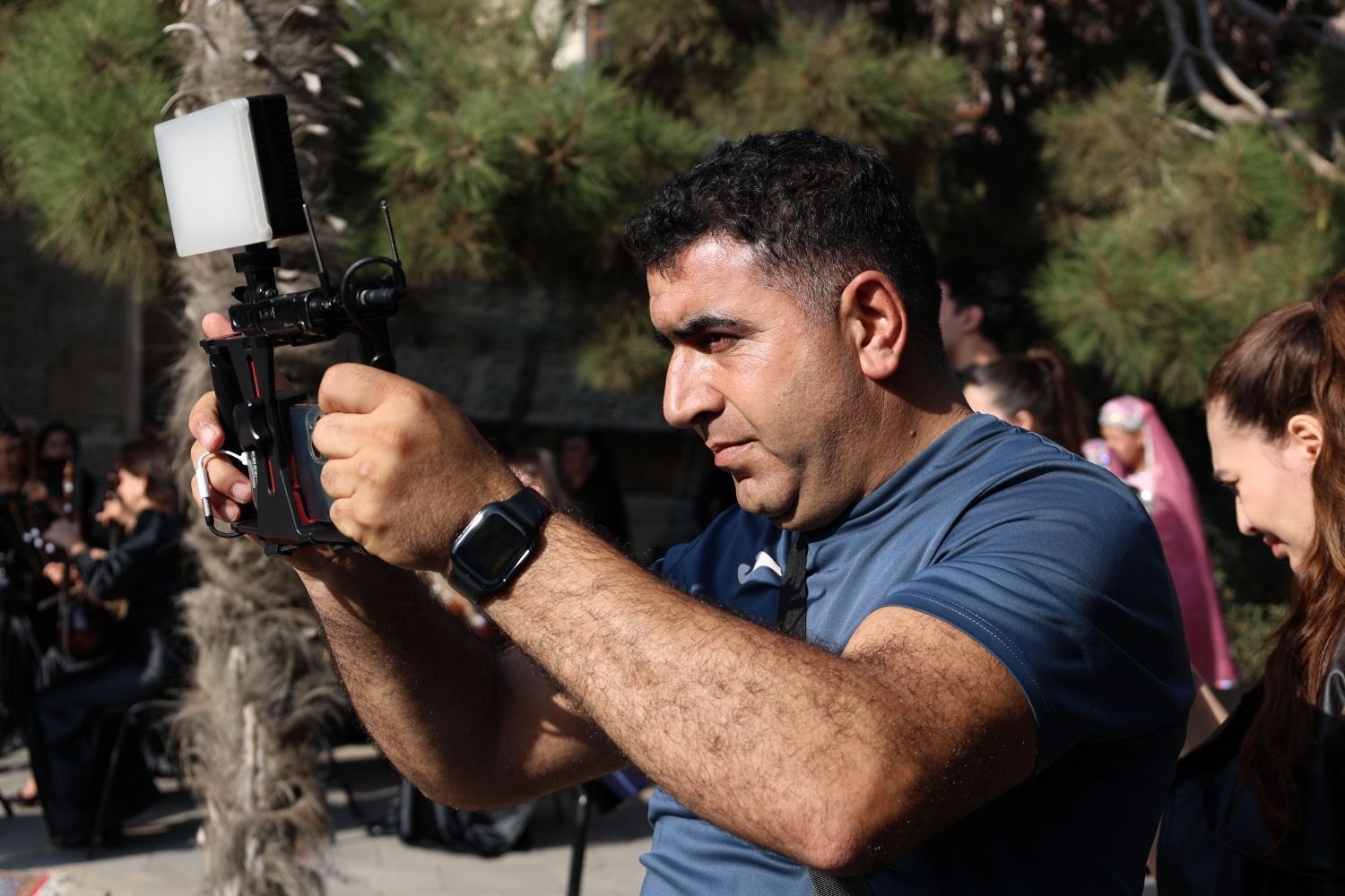 An operator holding a camera rig during an outdoor shoot.