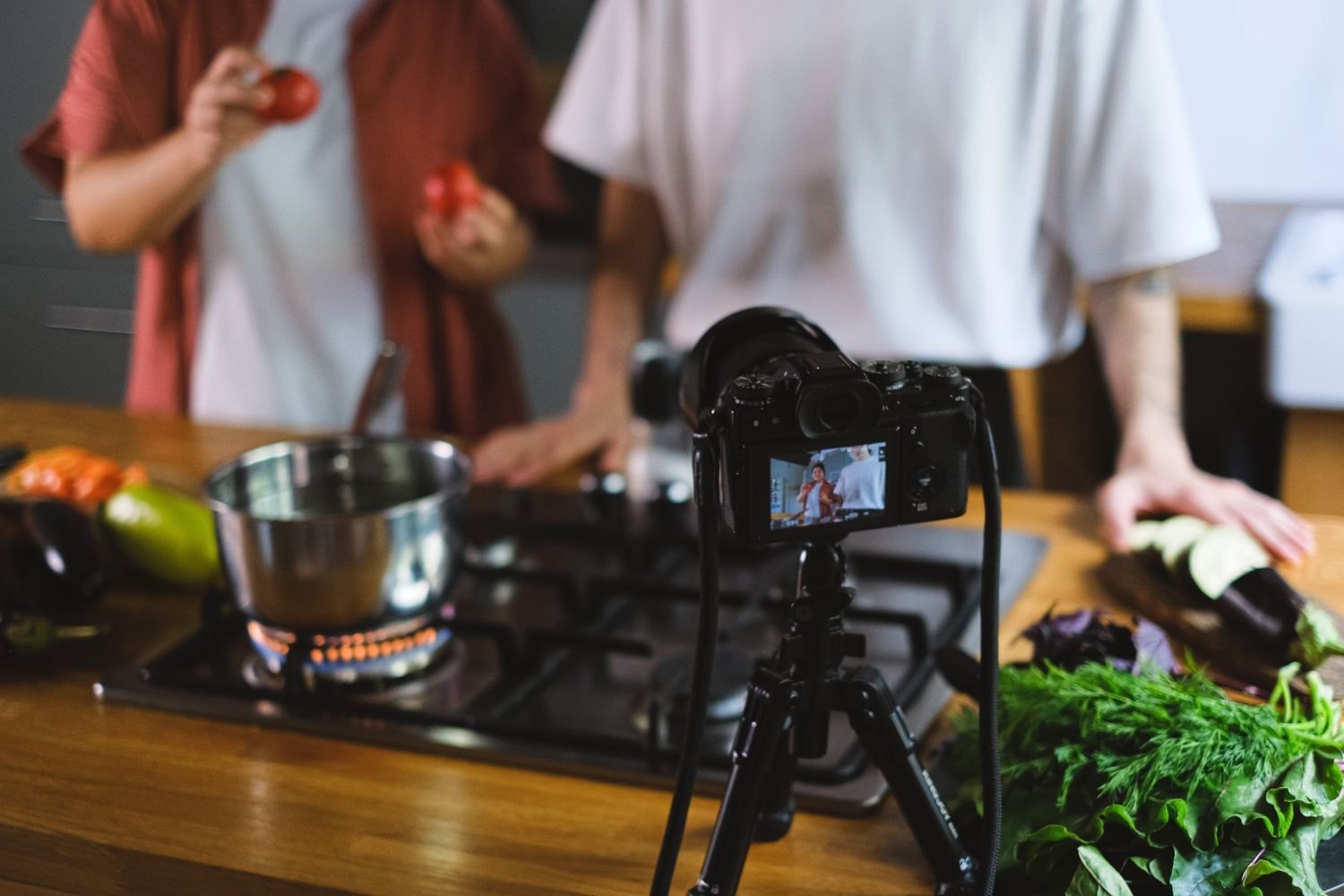 A cooking shoot with vegetables and a camera on a tripod.